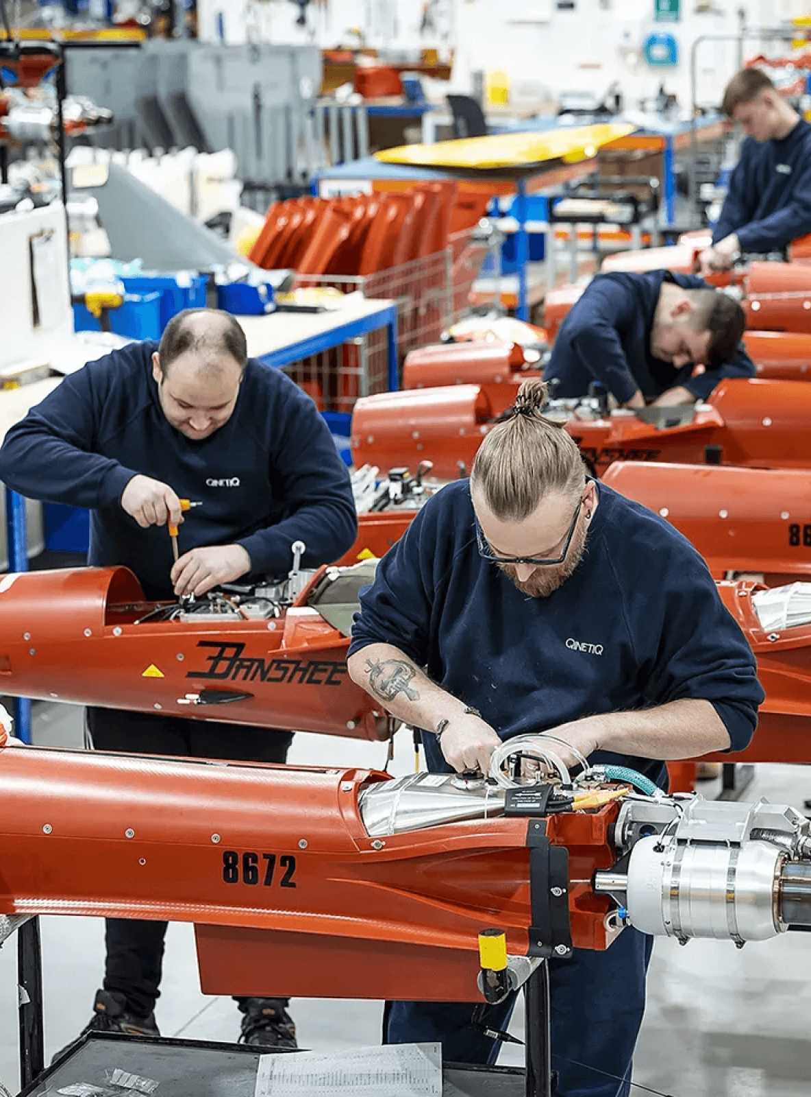 Bild von zwei Personen, die in einer Fabrik arbeiten.